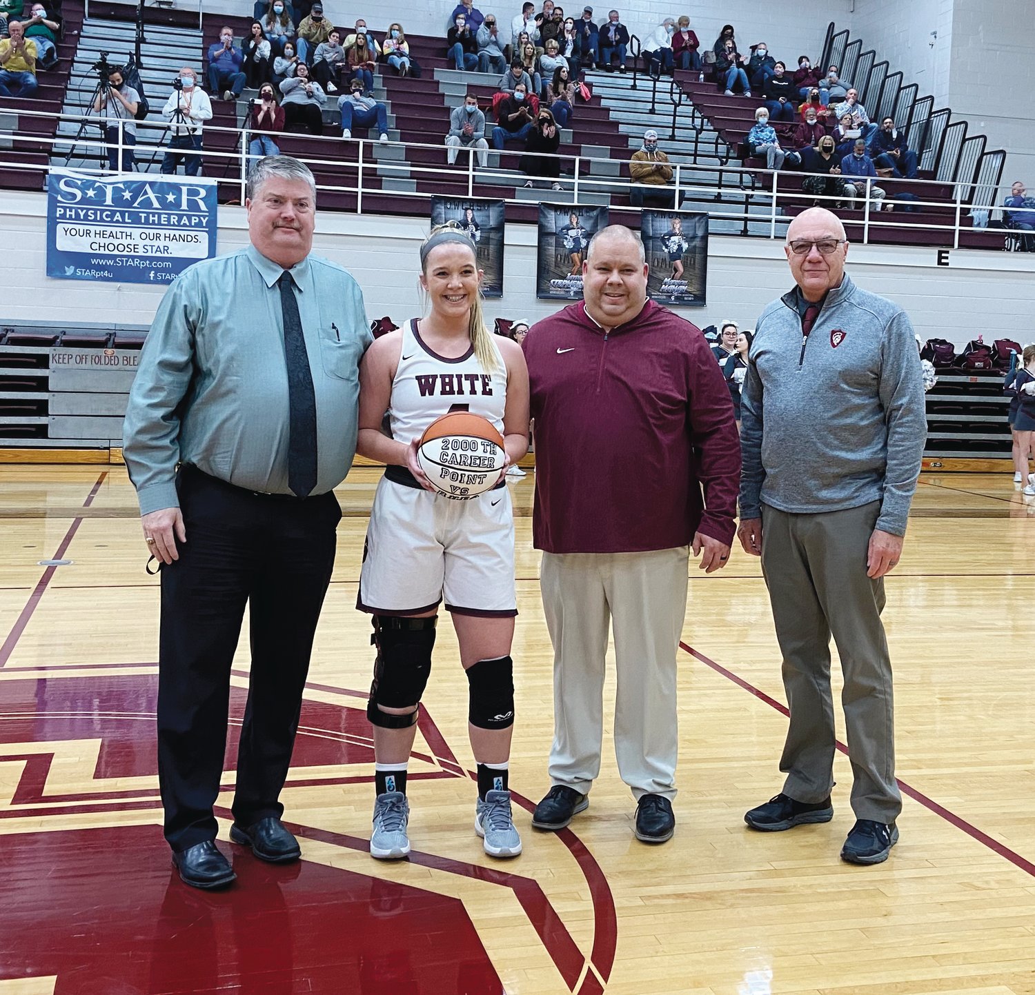 Gracie Dodgen scores her 2,000th career point during Tuesday night’s game.  L-R: White County High School  principal Greg Wilson, Gracie Dodgen, Coach Michael Dodgen, and athletic director Terry Crain.